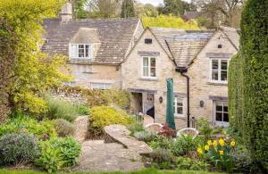 an old stone house with a garden in front of it at Willow Cottage in Hampnett