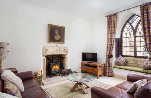 a living room with a couch and a fireplace at Little Culver in Minchinhampton