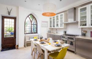 a white kitchen with a table and chairs in it at Little Culver in Minchinhampton