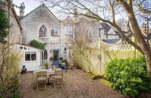 a backyard with a table and chairs and a fence at Little Culver in Minchinhampton