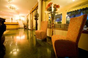 a lobby with two chairs and a vase of flowers at Hotel Atlantico in Castiglioncello