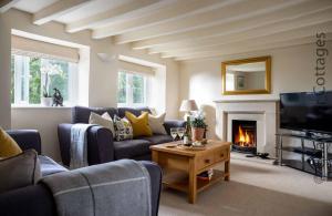 a living room with a couch and a fireplace at Weir Cottage in Bourton on the Water