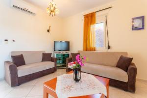 a living room with two couches and a tv at Villa Georgia in Gerani