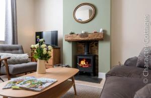 a living room with a fireplace and a table at Wall Cottage in Burford