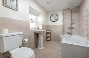 een badkamer met toilet, douche en wastafel bij Wall Cottage in Burford