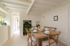 une salle à manger avec une table et des chaises en bois dans l'établissement Holly Cottage Middle Tysoe, à Middle Tysoe