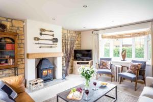 a living room with a fireplace and a table at Honeysuckle Cottage Middle Tysoe in Middle Tysoe