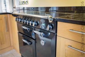 a black stove in a kitchen with a counter at Honeysuckle Cottage Middle Tysoe in Middle Tysoe