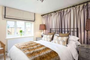 a bedroom with a large bed and a window at Honeysuckle Cottage Middle Tysoe in Middle Tysoe