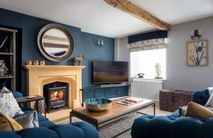 a living room with a fireplace and a mirror at Lavender Cottage Stow-on-the-Wold in Stow on the Wold