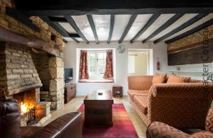 a living room with a couch and a stone fireplace at Court Hayes in Cheltenham