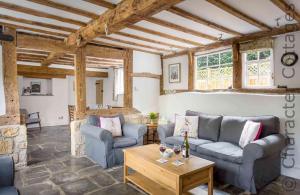 a living room with two couches and a table at April Cottage in Mickleton