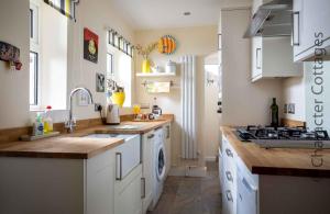 a kitchen with a sink and a stove top oven at Tukes Cottage in Chipping Norton