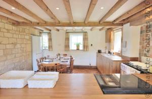 a kitchen and dining room with a table and chairs at Pye Corner Cottage in Broadway