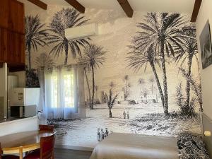 een slaapkamer met een muurschildering van palmbomen aan de muur bij L Incantu in Galeria +38 foto's