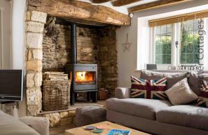 a living room with a couch and a fireplace at Wyncliffe in Chipping Campden
