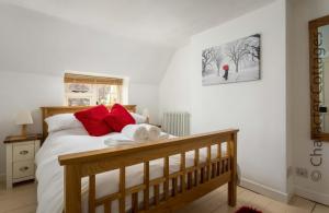um quarto com uma cama com almofadas vermelhas em Wyncliffe em Chipping Campden