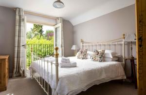 a bedroom with a white bed and a large window at East Leaze in Chipping Campden