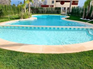 a swimming pool in the grass in a yard at Apartamento Infinium I - Exclusivo - Inmodream Calpe in Ifach