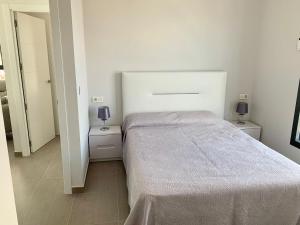 a white bedroom with a bed and two night stands at Apartamento Infinium I - Exclusivo - Inmodream Calpe in Ifach +11 photos