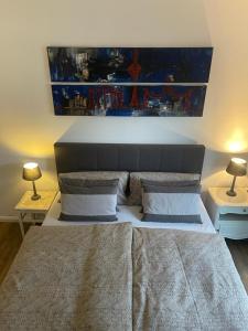 a bedroom with a large bed with two lamps on tables at COSY PANKOW HOMES - Studios mit TV Stick in Berlin