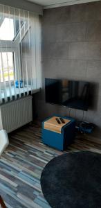 a living room with a tv and a blue box at Residentie Spinnaker in Blankenberge