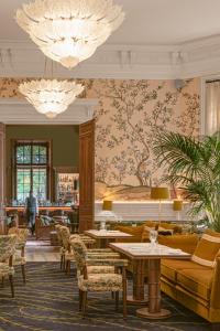 a hotel lobby with tables and chairs and a wallpaper at Saint James Paris in Paris