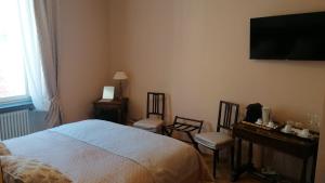 a bedroom with a bed and two chairs and a television at Al Molo di Sant'Agostino in Como