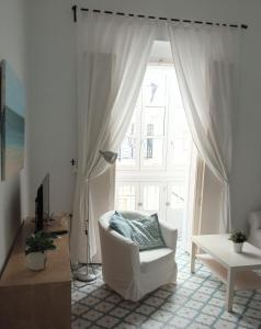 カディスにあるSagasta Apartmentsのリビングルーム(白い椅子、窓付)