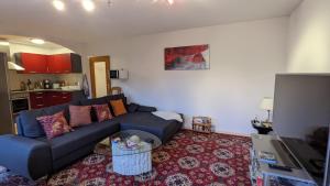 ein Wohnzimmer mit einem blauen Sofa und einem Tisch in der Unterkunft Taunusblick-Meißner in Schmitten
