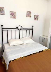 a bed in a bedroom with four pictures on the wall at Casinha alentejana in Évora