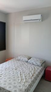 een slaapkamer met een wit bed en een wit dekbed bij Residencial Ponta das Canas in Florianópolis