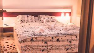 1 dormitorio con 2 cisnes en una cama con música en With a View Residence - Luxury Apartament - Panoramic view over the City en Brasov