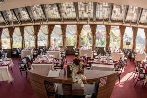 a banquet hall with tables and chairs and windows at With a View Residence - Luxury Apartament - Panoramic view over the City in Braşov