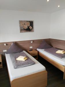 twee bedden in een kamer met handdoeken erop bij Pension & Appartments Landhaus Bettina Fulda in Fulda