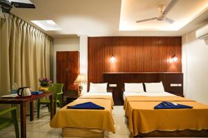 Ліжко або ліжка в номері Melanna Cherai Beach Resorts