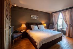a bedroom with a large bed and two chairs at Château de Planchevienne in Magny-Cours