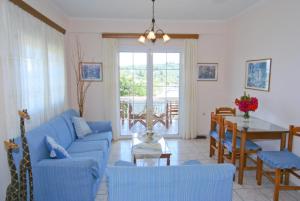 a living room with a blue couch and a table at Dolphin House in Porto Ozias