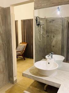 y baño con lavabo y ducha. en Villa Thotupola en Ahungalla