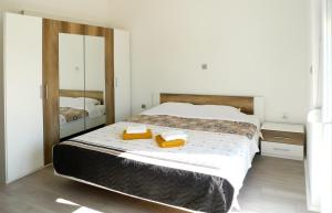 a bedroom with a bed with two towels and a mirror at Apartments Sunset in Olib