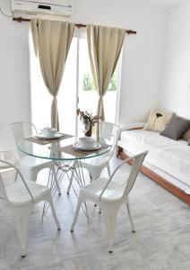 ein Esszimmer mit einem Glastisch und weißen Stühlen in der Unterkunft DEPTO KENIA II. ALQUILER TEMPORARIO SAN FRANCISCO in San Francisco