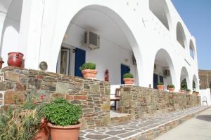 a stone wall with potted plants in front of a building at Tzamaros Studios in Mérikhas