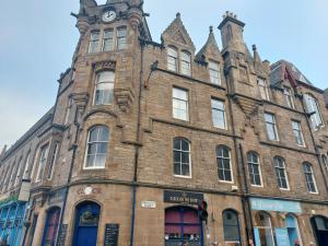 an old brick building with a clock tower on it at Sunshine On Leith Apartment in Edinburgh