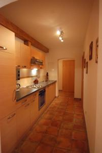 a kitchen with white cabinets and a tile floor at Apartment Kolb in Hippach