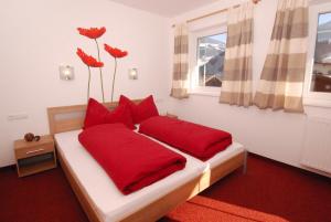 a bedroom with a bed with red pillows and a window at Apartment Kolb in Hippach