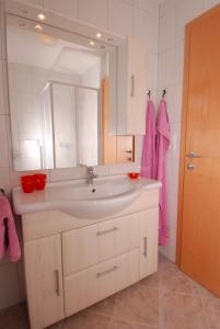 a bathroom with a sink and a mirror and pink towel at Apartment Kolb in Hippach