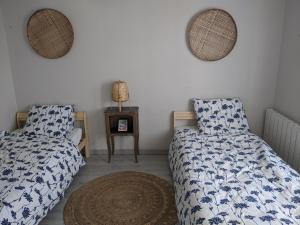 a bedroom with two beds and a table and mirrors at T3 à Mérignac, cosy et bien décoré in Mérignac