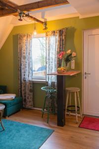 ein Wohnzimmer mit einem Tisch und einem Fenster in der Unterkunft Maisonette am Glockenturm in Südbrookmerland