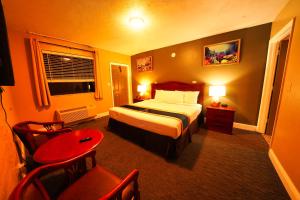 een hotelkamer met een bed en een tafel en stoelen bij Sandals Inn in Daytona Beach