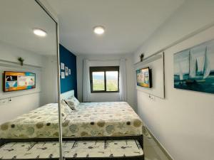 une petite chambre avec un lit et une fenêtre dans l'établissement Home 49 I Apto pé na areia e piscina aquecida em Bertioga, à Bertioga 98 autres photos